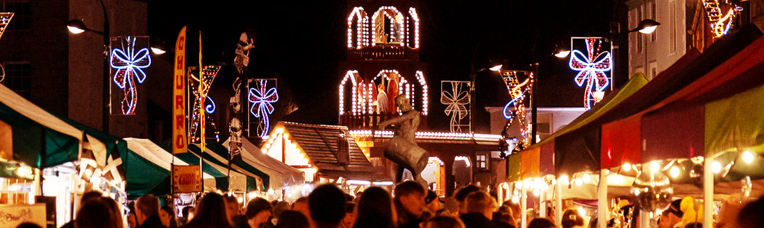 Truro's Lemon Quay Christmas market in the evening, looking down through the stalls of local makers.