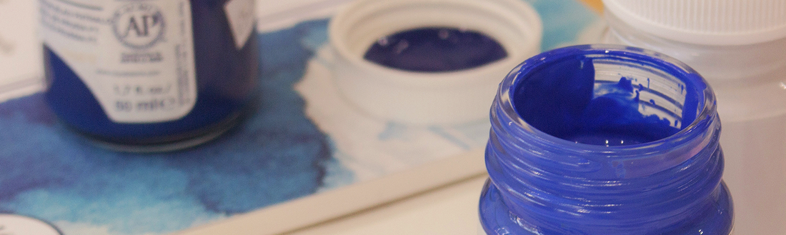 An open bottle of Cobalt Blue Royal Talens gouache paint in front of a watercolour paper pad.