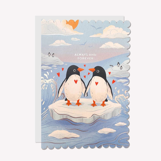 An illustrated anniversary card by Raven Paper Co, printed by Ricicle Cards. This card features two penguins standing together on an iceberg, with gold-foiled text above that reads “Always And Forever".