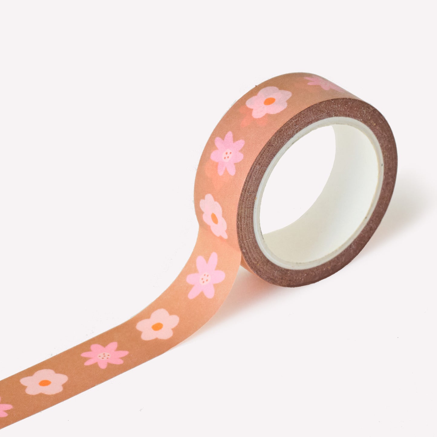 Roll of washi tape with a pattern of sweet pink flowers on a brown background. Each roll measures 15mm wide and has 10m of tape. Made by Claire Paul. 