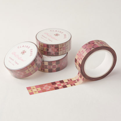 Stack of Patchwork Star washi tapes in their packaging with an open roll. Tapes feature a pink patchwork style pattern. Each roll measures 15mm wide and has 10m of tape. Made by Claire Paul. 