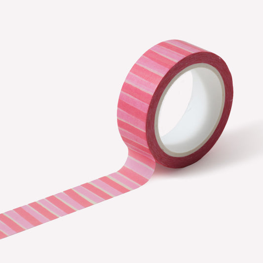 Roll of washi tape designed by Claire Paul, featuring a pattern of vibrant, light and dark pink stripes, cream background. Each roll measures 15mm wide and has 10m of tape. 