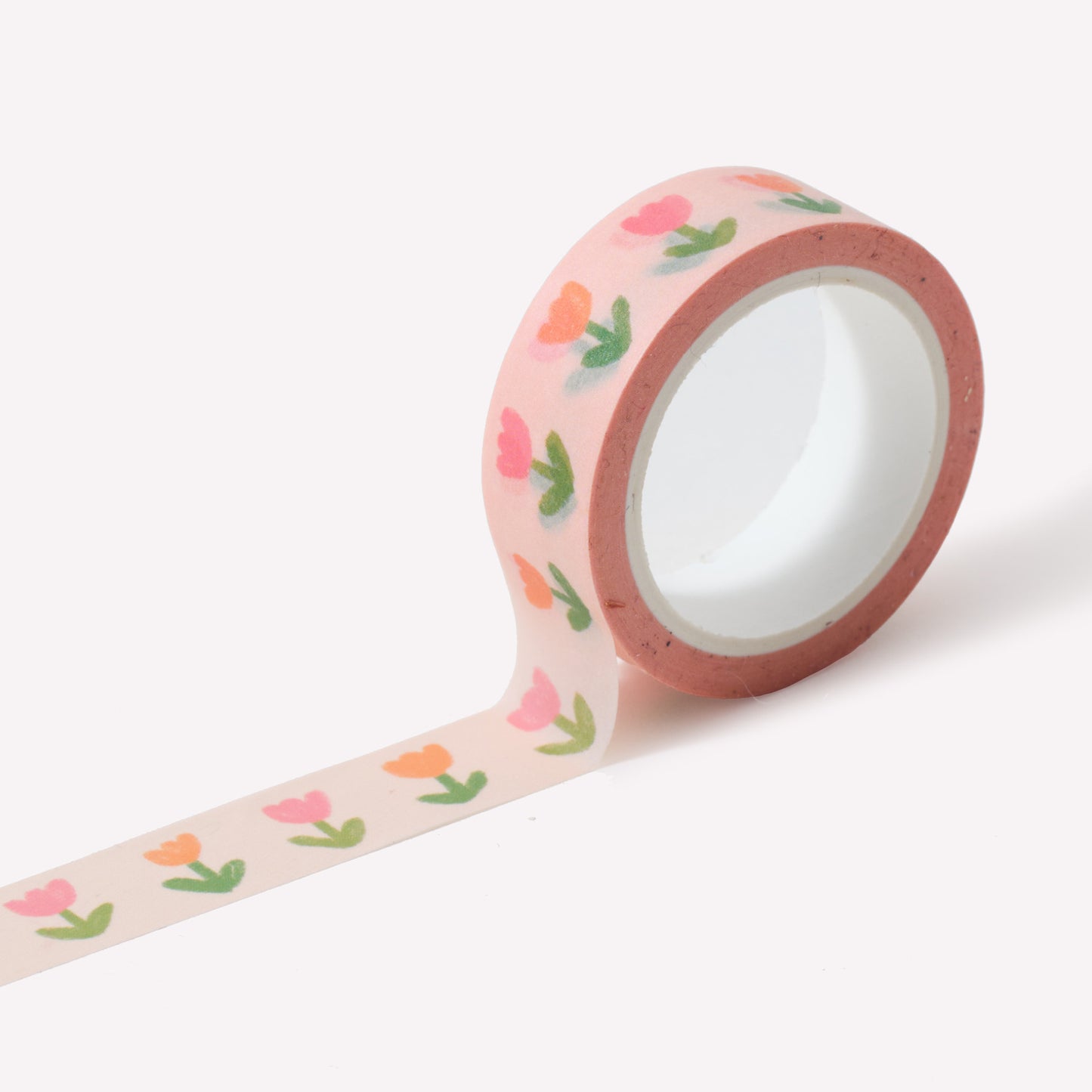 Roll of washi tape designed by Claire Paul, featuring a pattern of hand drawn flowers on a pale pink background. Each roll measures 15mm wide and has 10m of tape. 