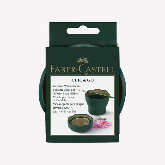 A 'Clic & Go' collapsable water pot by Faber-Castell, made from a flexible dark green rubber. The pot is collapsed flat and in cardboard packaging.