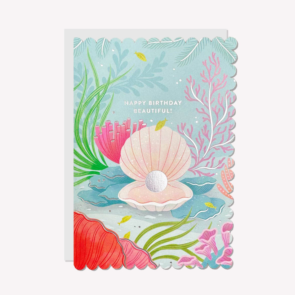 An illustrated birthday card by Raven Paper Co, printed by Ricicle Cards. This card features an illustration of an open oyster shell, with silver-foiled text above that reads “Happy Birthday Beautiful!".