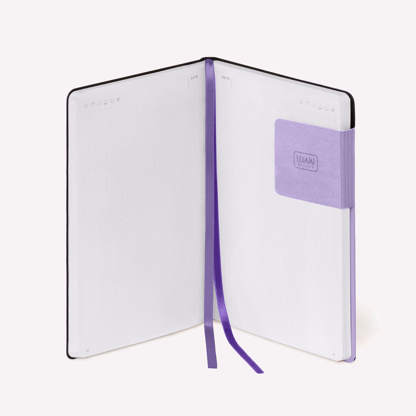 Legami "my notebook" dotted bullet journal with lavender cover open to show dotted apreads with weather details at the top of the page and a page marker that doubles as a pen holder. 