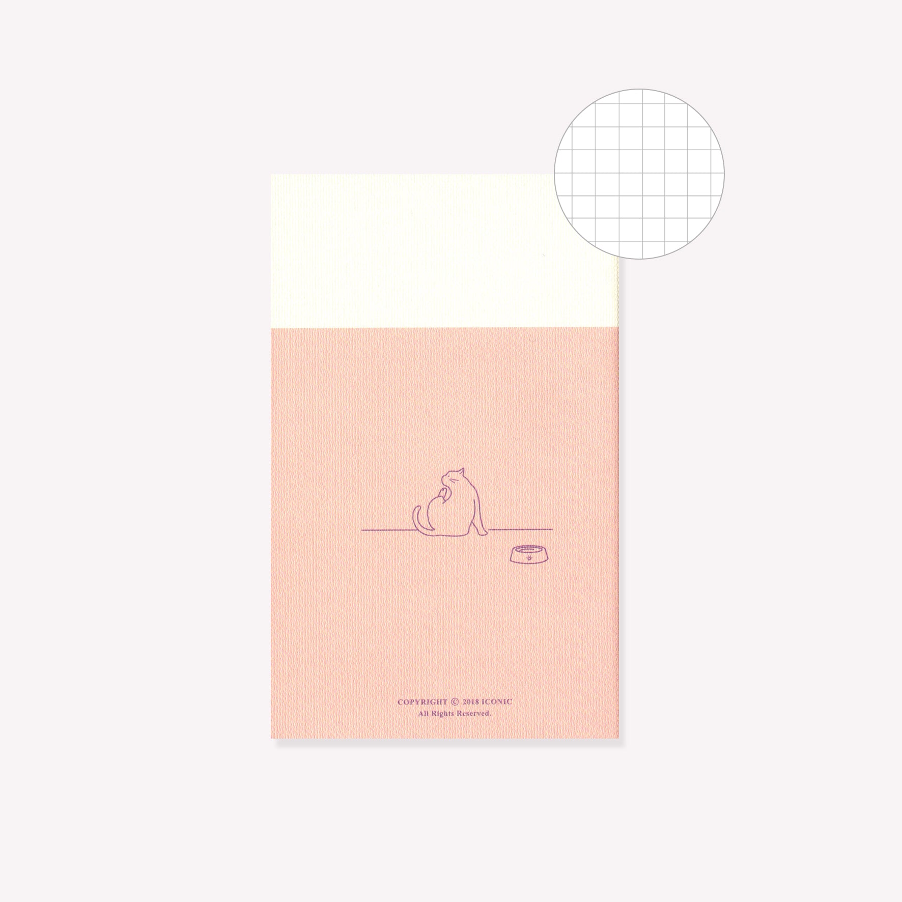 The back of the pink 'Yoga' design notebook by Iconic featuring a cat with their food bowl. A circular graphic indicates gridded pages inside.