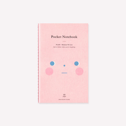 Iconic pocket stitchbound notebook with a pink soft cover illustrated with a pink shy smiley face. Plain/blank pages inside. 