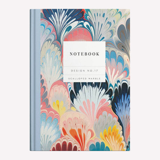 Ohh Deer Kaleido hard cover notebook with a blue and coral scallop marble design and a blue spine binding, containing 192 lined pages. 