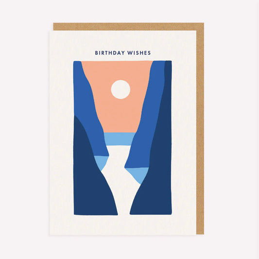 An illustrated birthday card by Miles Tewson, printed by Ohh Deer. This card features an orange and blue illustration of the sea between two cliffs, with text above that reads “Birthday Wishes”.