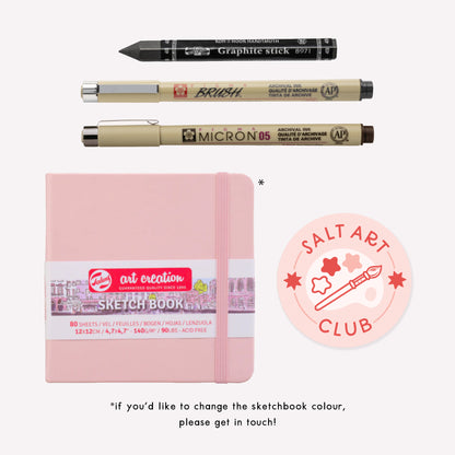 "Start a Sketchbook" christmas gift set including a pink sketchbook, graphite stick, brush pen, fineliner and Salt Art Club sticker. 