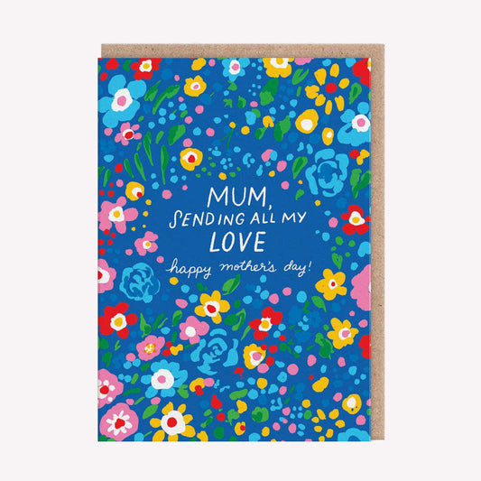 An illustrated Mother's Day card by Hello! Lucky, printed by Ohh Deer. This card features a pattern of flowers on a blue background, with text in the center that reads “Mum, Sending All My Love, Happy Mother's Day”.