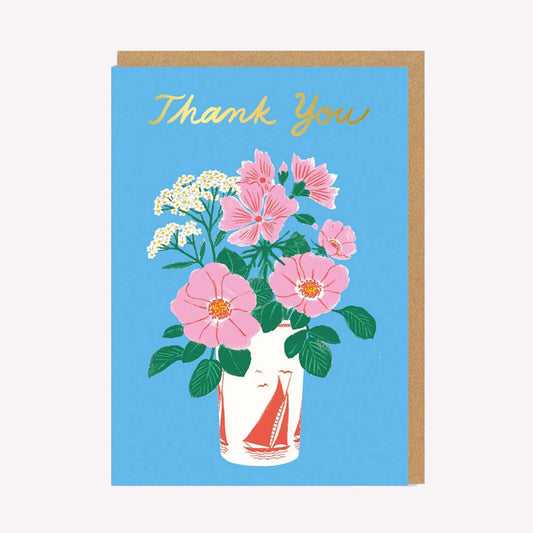 An illustrated thank you card by Ohh Deer. This card features a vase of pink and white flowers on a bright blue background, with text above that reads “Thank You.